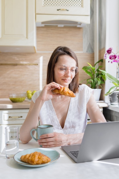 Mujer europea prepara café en casa en su cocina y disfruta de sus buenos días por la mañana