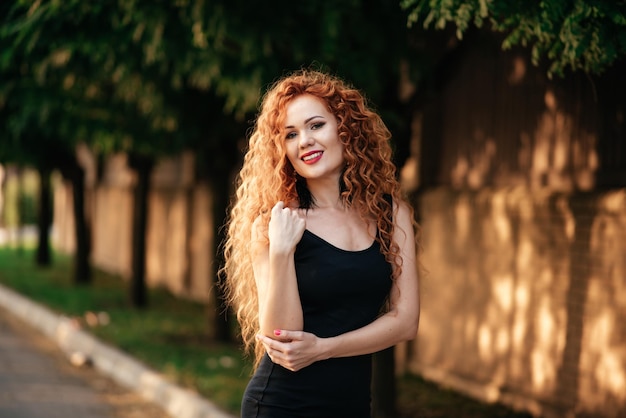 Mujer europea de talla grande caminando al aire libre en la calle de la ciudad Chica joven de cuerpo positivo de pelo rosa rojo