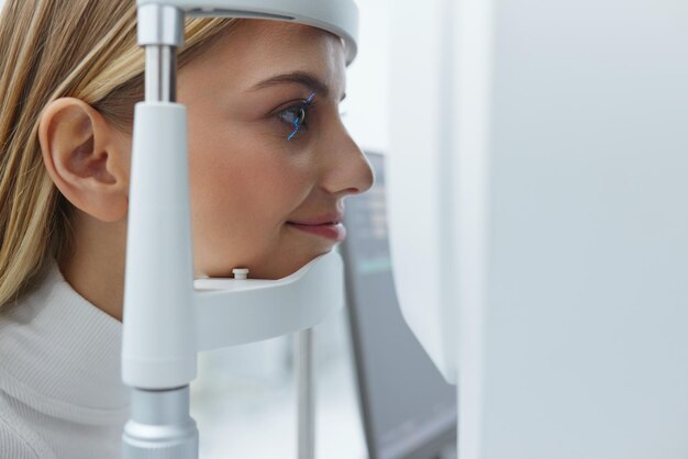 Foto mujer de examen de la vista que comprueba la visión del ojo en el equipo de optometría