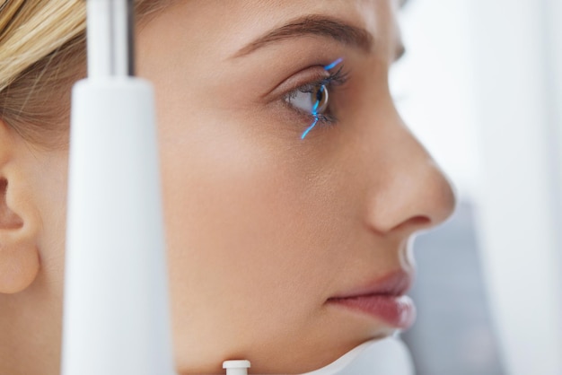 Foto mujer de examen de la vista que comprueba la visión del ojo en el equipo de optometría