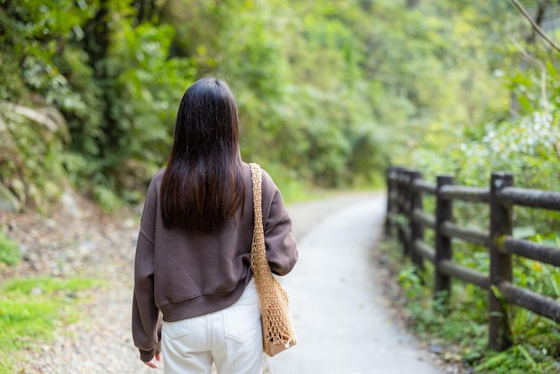 Mujer va de excursión en el campo del bosque