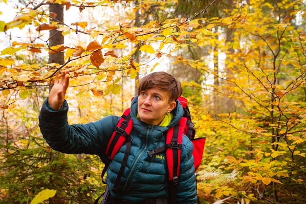 Mujer excursionista se está tomando una selfie en el bosque de otoño