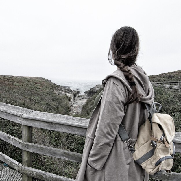 Foto mujer excursionista de pie en un punto de observación por las montañas contra el cielo