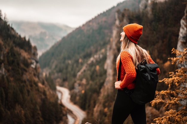Mujer excursionista se sienta y disfruta de la vista del valle desde el mirador El caminante llegó a la cima de la montaña y se relaja Eslovaquia mala fatra Aventura y viajes en la región montañosa