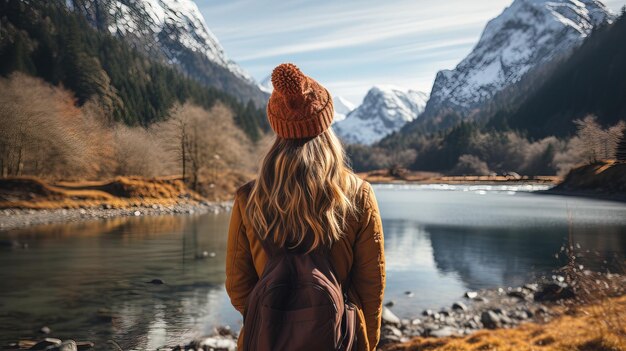 Mujer excursionista con sombrero de invierno disfrutando de una vista tranquila del lago