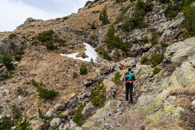 Mujer excursionista con su perro en el Parque Nacional de Aiguestortes y el lago de Sant Maurici.