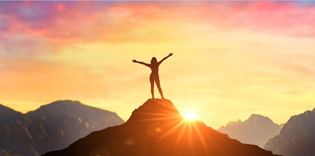 Mujer exitosa ha logrado un nuevo pico de crecimiento y desarrollo personal Mujer en la cima de la montaña con los brazos abiertos dando la bienvenida a un nuevo día con el ganador del liderazgo empresarial exitoso del amanecer en la cima