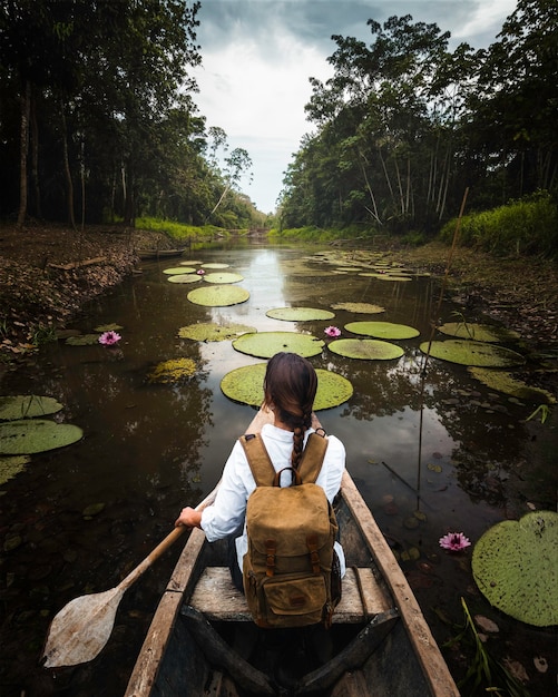 Foto mujer exploradora viaja en canoa por el río amazonas