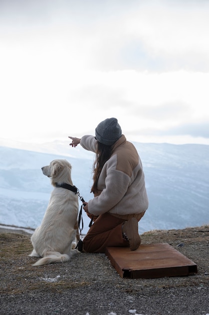 Foto mujer explorando con su labrador durante un viaje de invierno