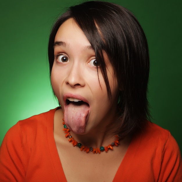 Mujer de expresión joven sobre fondo verde, tiempo feliz