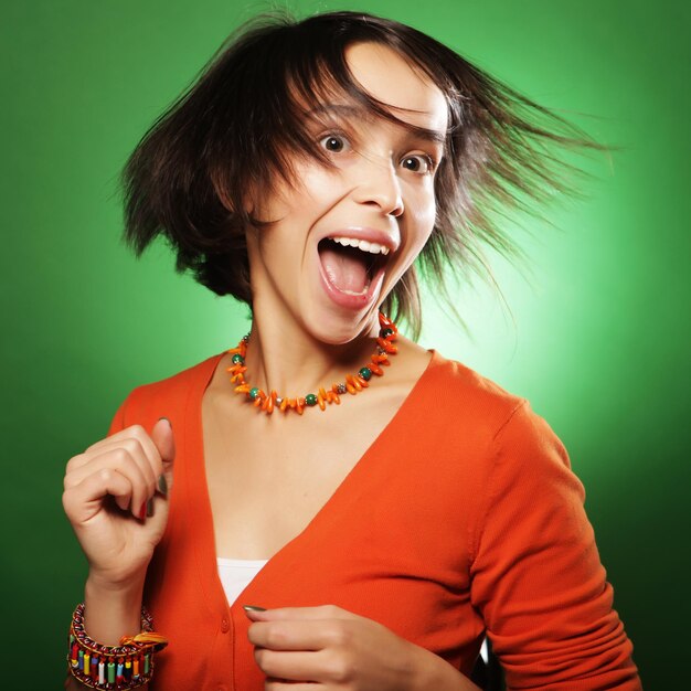 Foto mujer de expresión joven sobre fondo verde, tiempo feliz