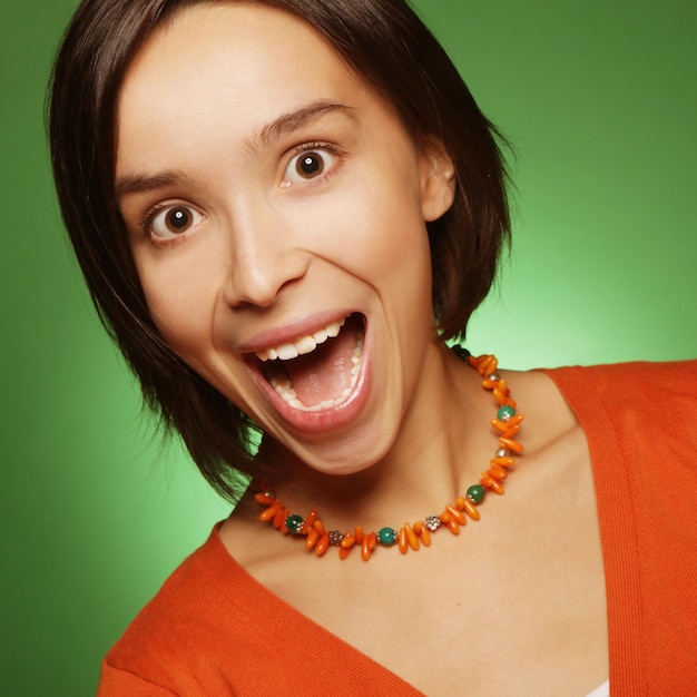 Mujer de expresión joven sobre fondo verde, tiempo feliz