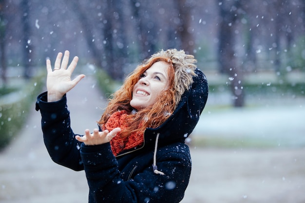 Foto mujer con una expresión de sorpresa bajo la nieve.