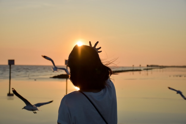 Foto la mujer extendió su mano hacia el cielo con la gaviota volando.