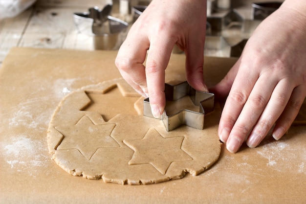 Una mujer extiende la masa y corta las galletas.