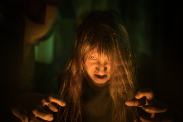 Foto mujer fantasma aterrador gritando a través del vidrio sucio sobre fondo oscuro