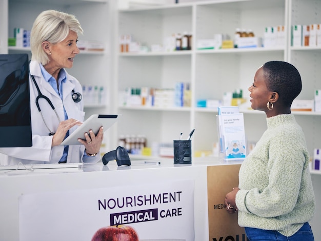 Mujer farmacéutica y tableta para consultar la receta del paciente o el consejo de atención médica en la farmacia Mujer o profesional médico con tecnología hablando con el cliente en consulta en la clínica