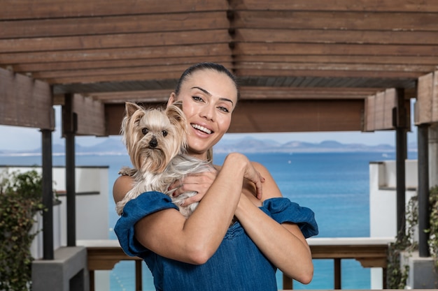 Mujer feliz abrazando perro en terraza
