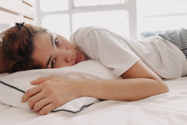 Mujer feliz acaba de despertar en su cama en una cálida mañana de verano