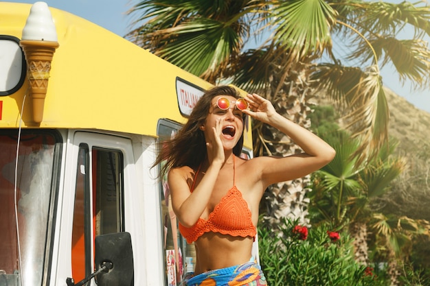 Mujer feliz al lado del autobús de helados