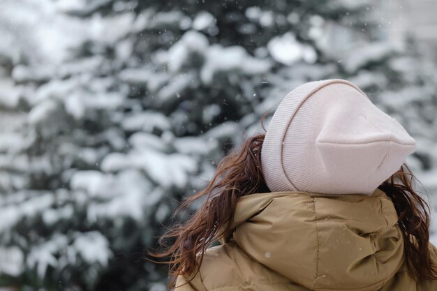 Foto mujer feliz atrapando copos de nieve en la ciudad en invierno