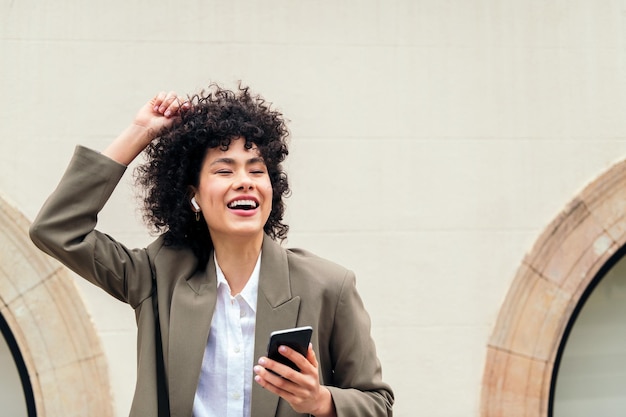 Mujer feliz con auriculares bailando con la música