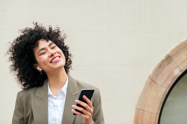 Mujer feliz con auriculares sonríe escuchando música