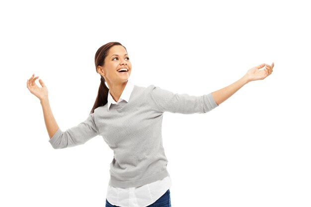 Mujer feliz bailando y música con las manos abiertas para la celebración o la libertad en el estudio sobre un fondo blanco Persona femenina joven o modelo emocionado con actitud despreocupada para ganar buenas noticias o alivio