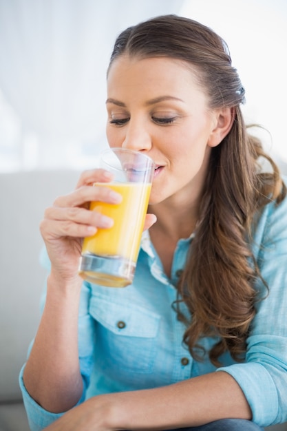 Foto mujer feliz bebiendo jugo de naranja