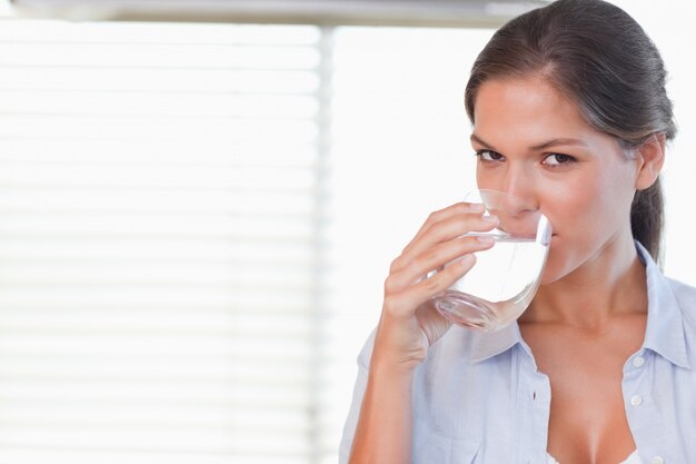 Mujer feliz bebiendo un vaso de agua