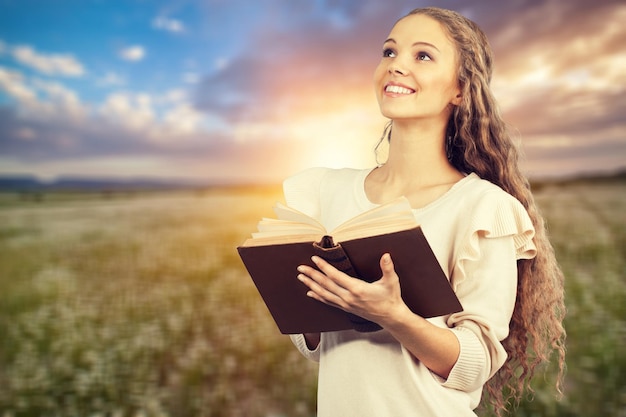 Foto mujer feliz con biblia sobre fondo claro