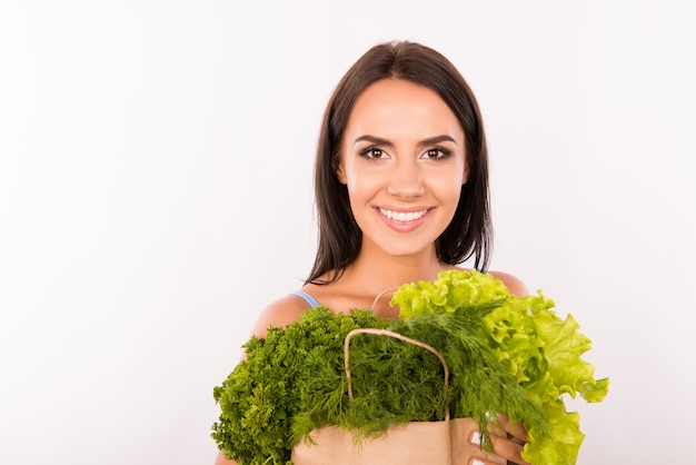 Mujer feliz con bolsa llena de verduras y verduras