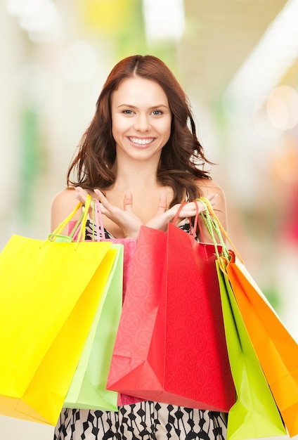 mujer feliz con bolsas de la compra en el centro comercial