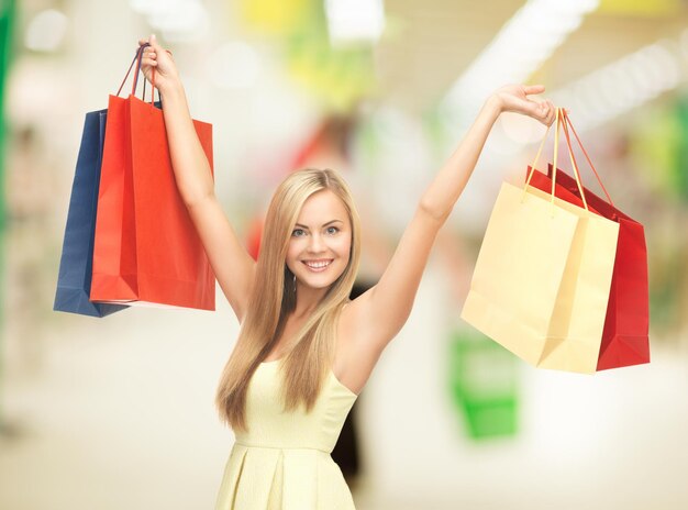 mujer feliz con bolsas de la compra en el centro comercial