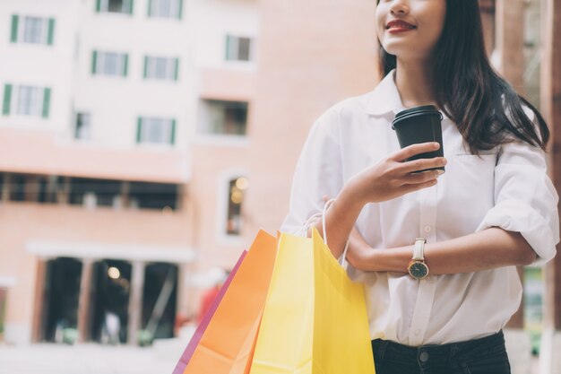 Mujer feliz con bolsas de compras disfrutando en las compras.