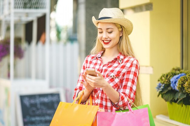 Mujer feliz con bolsas de compras disfrutando de compras.