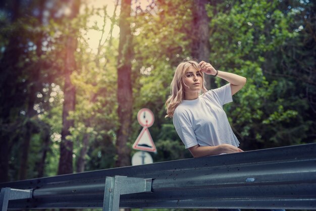 Mujer feliz en el bosque disfruta de tiempo de verano libre sobre fondo de bosques