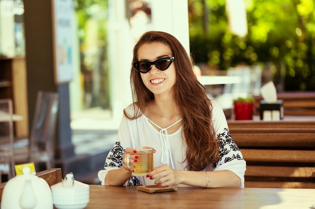 Mujer feliz en el café al aire libre