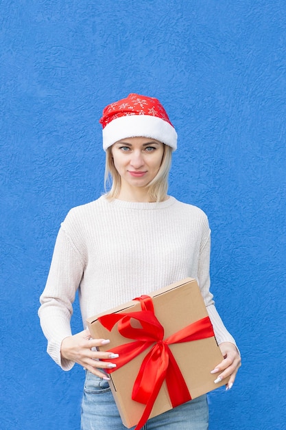Una mujer feliz con una caja de regalo en sus manos Fiestas y eventos de Navidad