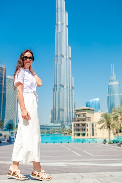 Mujer feliz caminando en Dubai con rascacielos