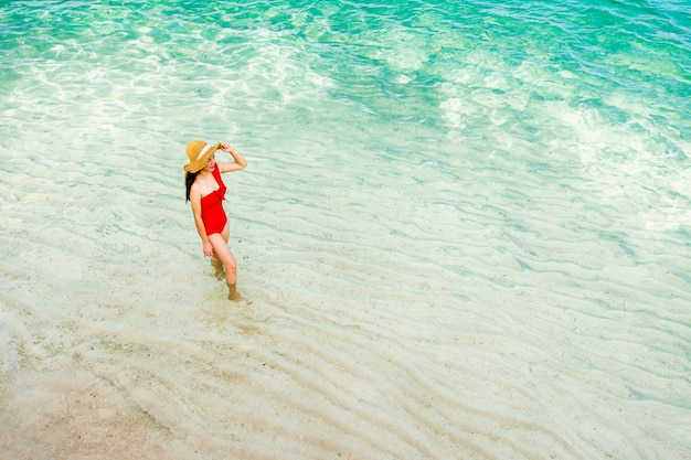 Mujer feliz caminando por la playa en la isla de Koh MunNork, Rayong, Tailandia