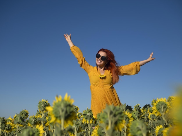 Mujer feliz en campo con girasoles florecientes