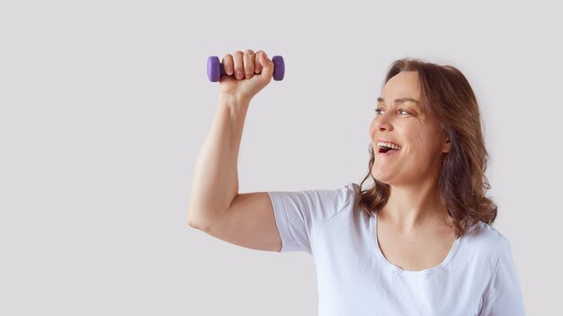 Mujer feliz en casa trabajando con pesas