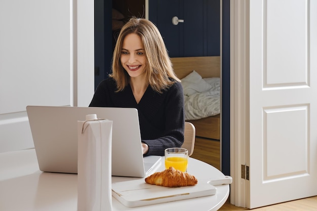 Mujer feliz chateando en línea desde casa