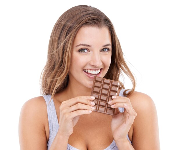 Foto mujer feliz comer chocolate y retrato con caramelo diente dulce y placer para el deseo de azúcar en el fondo del estudio bocadillo feliz y comida para la comodidad postre o dulces para calorías dieta o tentación