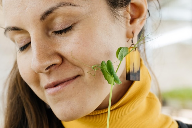 Mujer feliz comiendo brotes recién cortados de superalimento microverde