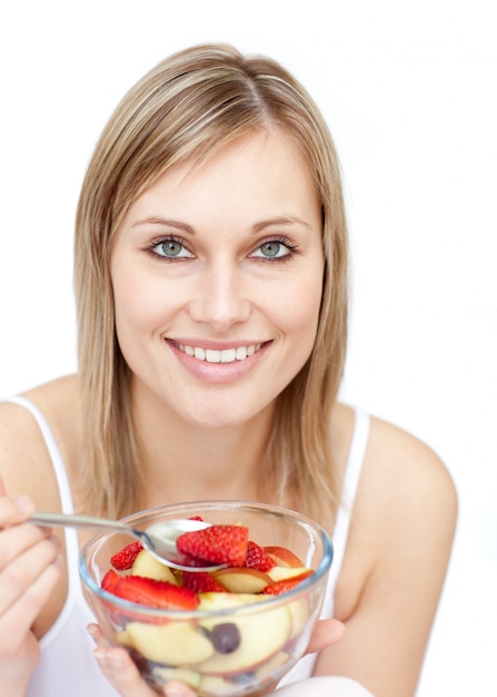 Mujer feliz comiendo una ensalada de frutas