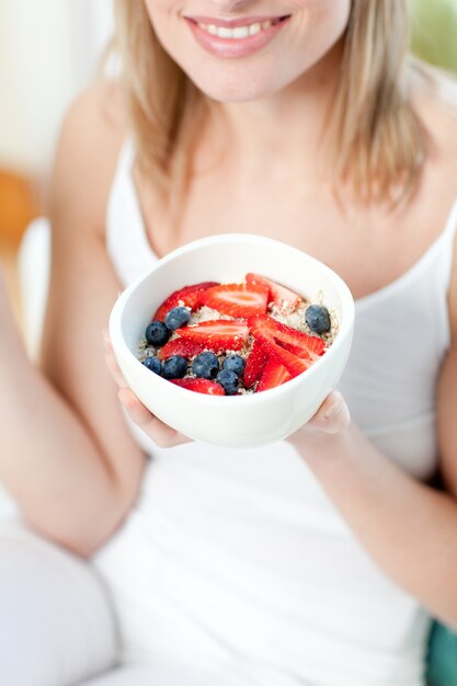 Mujer feliz comiendo muesli con frutas