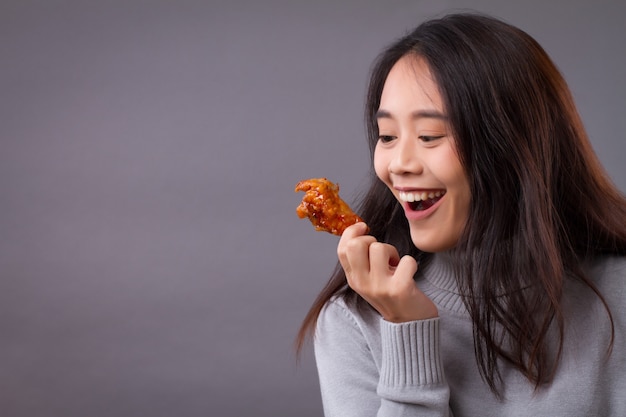 Mujer feliz comiendo pollo frito