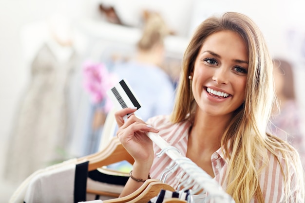 Mujer feliz comprando ropa con tarjeta de crédito